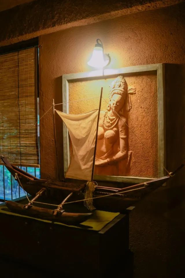 The model outrigger canoe and a carved figure on the wall of the Quadruple Family Cottage