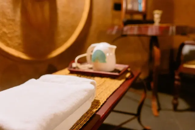 A tea tray with a kettle and folded towels in the Triple Room Cottage