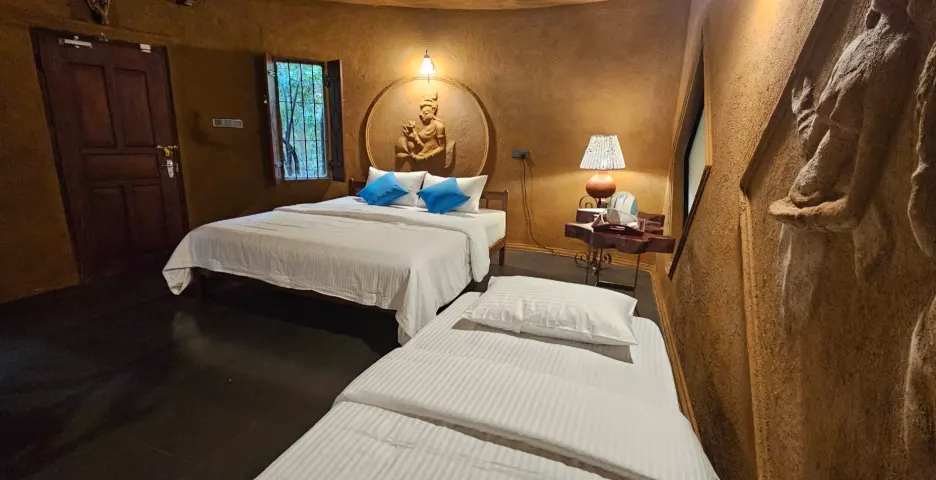 The king bed and the single bed in the Triple Room Cottage, with the door beyond