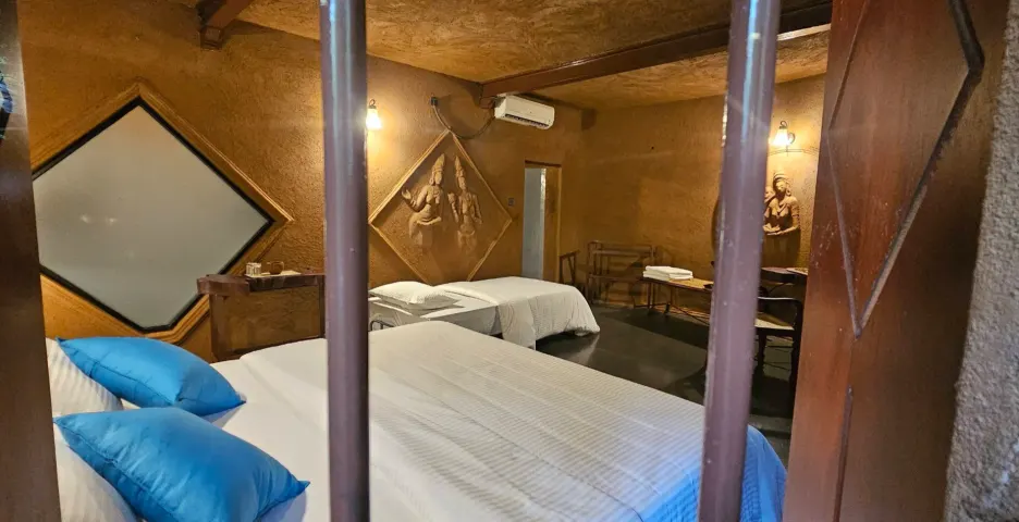The beds in the Triple Room Cottage, seen through the bars of a window