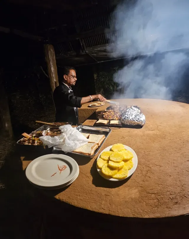 The barbecue in full smoke, the chef at the grill after dark