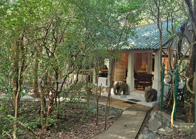 The dining pavilion among the trees, elephant carvings at its door