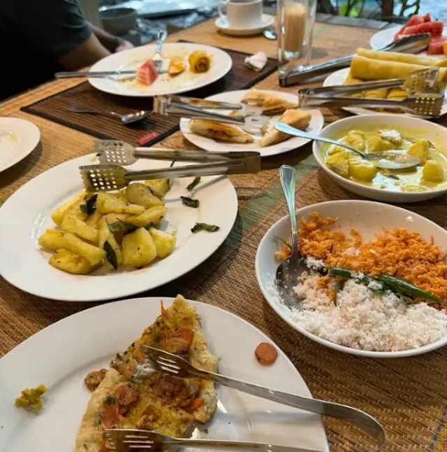 Dishes at lunch: pineapple, coconut sambol, a white curry and flatbreads