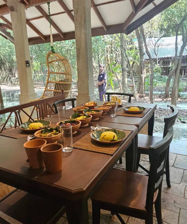 The long table in the pavilion laid with curries in clay pots
