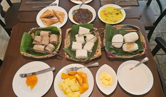 Breakfast laid out: pittu, string hoppers, bread, fruit and small curries