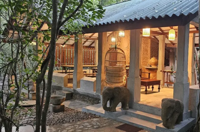The open-sided dining pavilion at Sigiriya Wild Cottages, lit at dusk