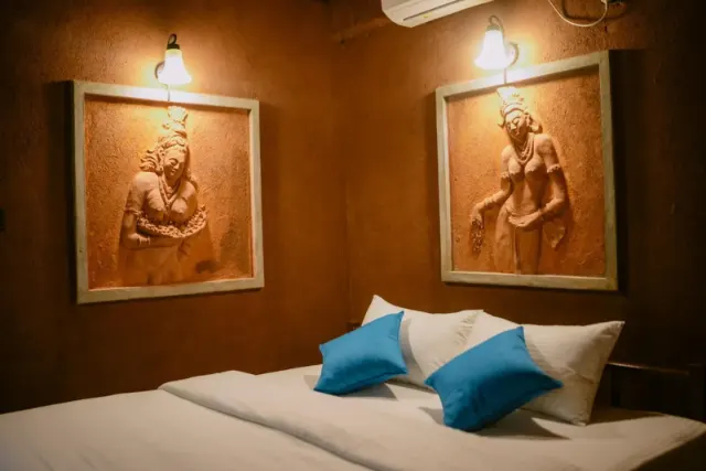 A cottage bedroom with two large framed reliefs