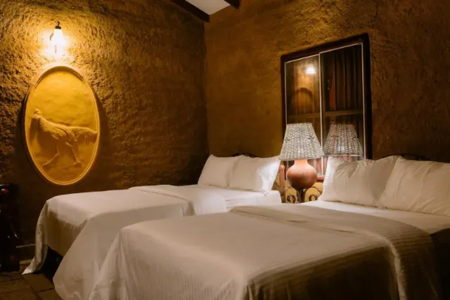 Two double beds with lamps below an oval relief