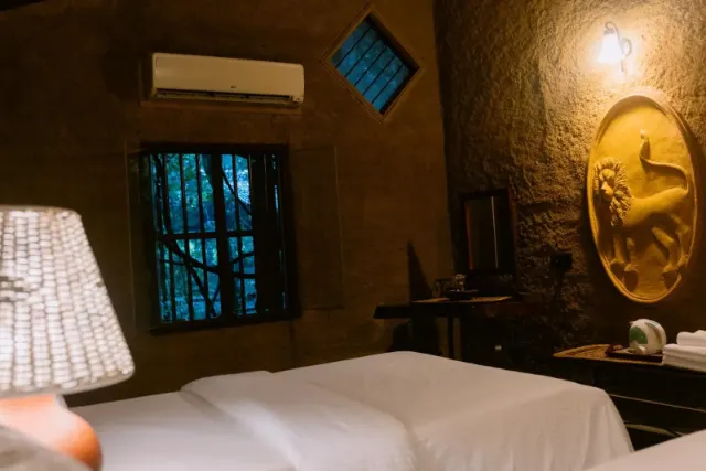 A cottage bedroom with air conditioning and a window onto the trees