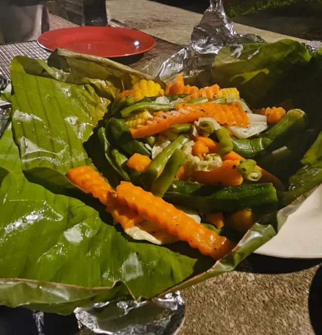 Carrot, beans and pumpkin wrapped in a banana leaf, ready for the fire