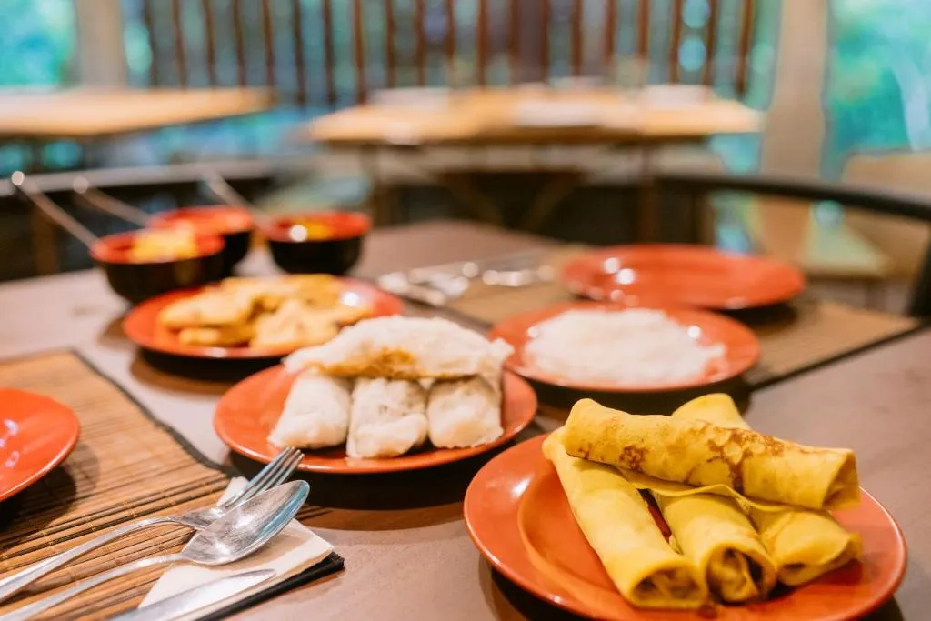 Breakfast plates of steamed rolls, rolled pancakes and rice